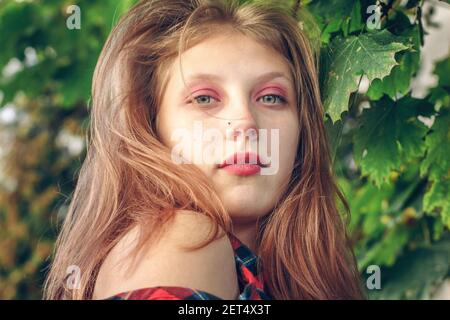 Attraktive junge Frau auf grünem Blatt Hintergrund. Portrait von schönen zarten 16 Jahre altes Mädchen Stockfoto