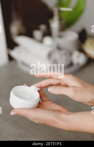 Nahaufnahme der Frau Hände halten Behälter mit Hautpflegecreme in den Händen. Stockfoto