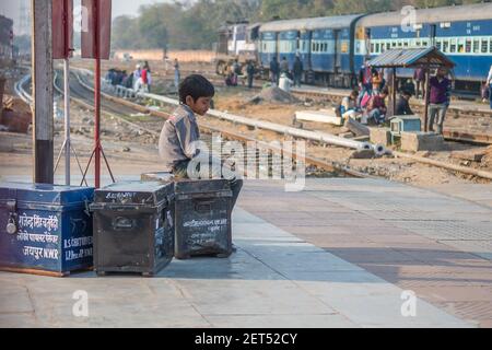 Jaipur, Indien. 09-05-2018. Ein einsamer Junge sitzt mit seiner Zugehörigkeit am Hauptbahnhof in Jaipur. Stockfoto