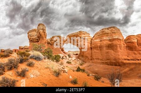 Der berühmte Broken Arch im Arches National Park, Utah und dramatische dunkle Wolken Stockfoto