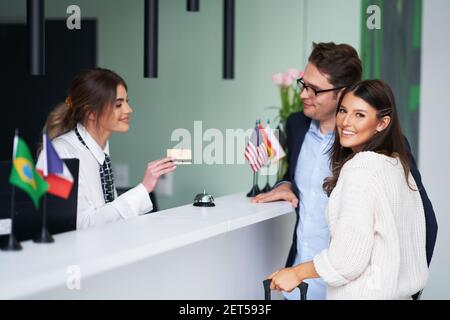 Erwachsenes Paar, das in einem Hotel eincheckt Stockfoto