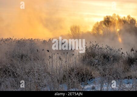 sonnenaufgang über dem See an einem frostigen und nebligen Morgen Stockfoto