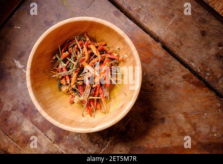 Getrocknete Chilis in einer rustikalen Holzschüssel von oben. Stockfoto