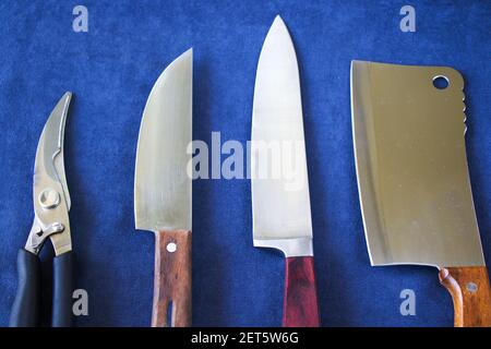 Die Küchenmesser-Kollektionen auf dem blauen Hintergrund, Werkzeuge und Instrumente zum Kochen. Stockfoto