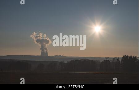 Temelin, Tschechische republik - 02 28 2021: Kernkraftwerk Temelin, dampfende Kühltürme in der Landschaft am Horizont bei Sonnenuntergang Stockfoto