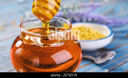 Honig im Glas mit Honig Dipper auf Holzhintergrund Stockfoto