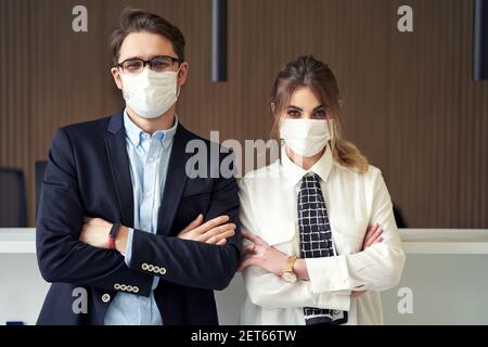 Die Angestellten an der Rezeption trugen eine Maske und arbeiteten in einem Hotel Stockfoto