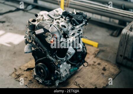 Ein Verbrennungsmotor, der zur Reparatur aus einem Fahrzeug entfernt wurde. Austausch des Motors an einer Tankstelle nach einem Ausfall der Hauptleitung. Stockfoto