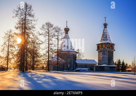 Alte russische Holzkirche der Dreikönigin mit dem Glockenturm im Dorf Oschewensk, Archangelsk Gebiet, Russland. Winter Morgen ländliche Landschaft Stockfoto