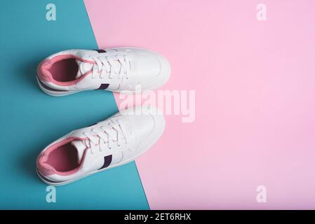 Flache Lay von Sport Sneakers Schuhe auf dem blauen und rosa Hintergrund. Fitness-Hintergrund. Gesundes Lifestyle-Konzept. Stockfoto