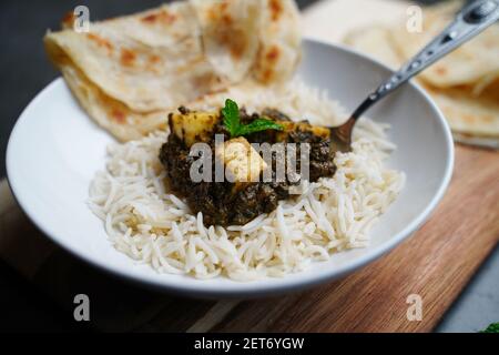 Palak Paneer oder Saag Paneer-indischer Hüttenkäse mit Spinat serviert mit Reis und Roti, selektiver Fokus Stockfoto