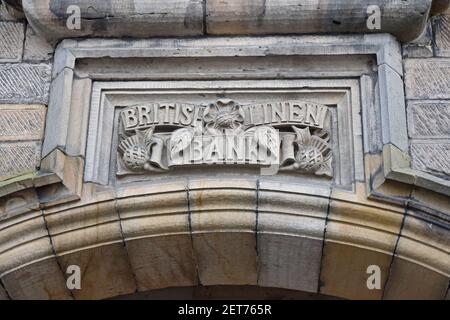 Logo der British Linen Bank und Text auf geschnitztem Mauerwerk über dem Türsturz. Falkland, Schottland, Großbritannien. Dies ist eine historische Bank, die nicht mehr existiert. Stockfoto