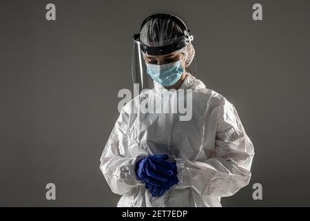 Ärztin in PSA trägt Schutzbrille Handschuhe Gesichtsmaske und nehmen Sie aus Gefahrgut-Suite. Stockfoto