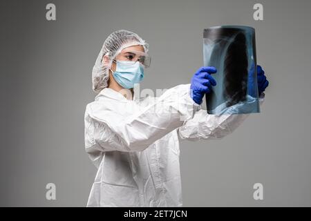 Pneumologin oder Onkologin mit Röntgenaufnahme des Brustkorbs, Untersuchung von COVID-19-Patienten Lungen, tragen PSA-Uniform, Coronavirus akute respiratorische Virus Stockfoto