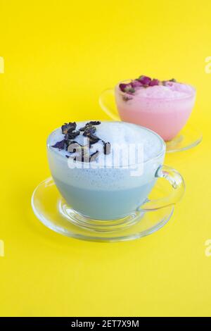 Blaue und rosa Mondmilch in Glasbechern auf der gelben Oberfläche. Position vertikal. Speicherplatz kopieren. Stockfoto