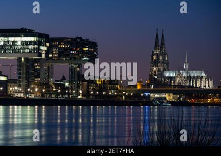 Köln, Deutschland. März 2021, 01st. Der Abendhimmel erstrahlt über dem Rheinpanorama mit den Kranichhäusern (l), dem Dom (r). Quelle: Oliver Berg/dpa/Alamy Live News Stockfoto