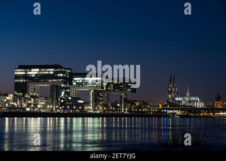 Köln, Deutschland. März 2021, 01st. Der Abendhimmel leuchtet blau über dem Rheinpanorama mit den 3 Kranhäusern (l), dem Dom (M) und der Kirche Groß St. Martin (r). Quelle: Oliver Berg/dpa/Alamy Live News Stockfoto