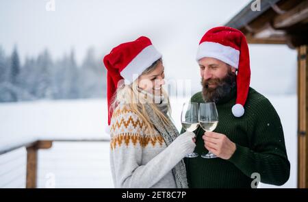 Glückliches Paar Wein trinken auf der Terrasse im Winter Natur, Urlaub zu Weihnachten. Stockfoto