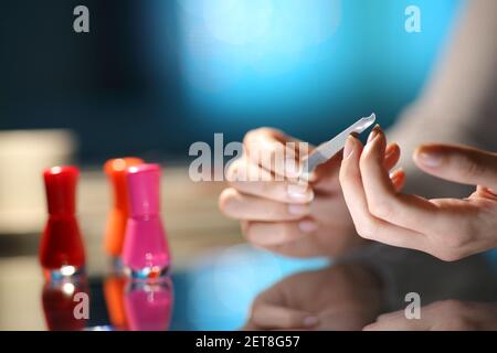 Nahaufnahme einer Frau Hände Feilen Nägel bereit Maniküre in der Nacht zu Hause Stockfoto