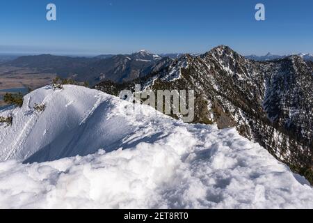 Bergrücken von Heimgarten in Bayern nach Herzogstand mit Schnee. Blauer Himmel, gutes Wetter, im Winter. Panoramablick auf die Berge. Stockfoto