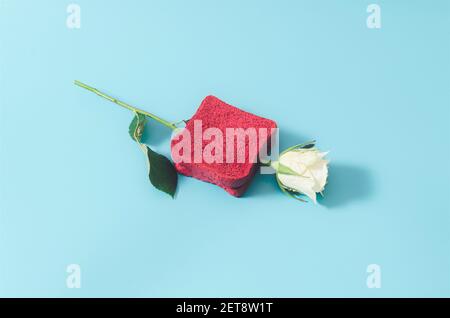 Eine weiße Rose zwischen zwei rosafarbenen Toastscheiben auf einem pastellblauen Hintergrund. Minimales kreatives Lebensmittelkonzept. Banner. Stockfoto