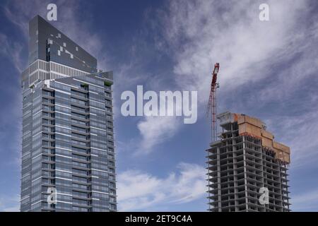 Ein Baukran baut ein hohes Wohngebäude in der Innenstadt in Calgary, Alberta, Kanada. Stockfoto