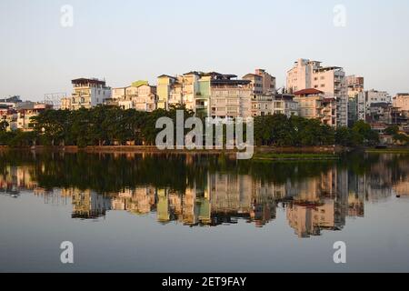 Öffentlicher Stadtpark in der Nähe von Tay See in der Innenstadt von Hanoi, Vietnam. Wohnhäuser spiegeln sich im Wasser Stockfoto