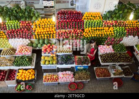 Da Lat, Vietnam - Juli, 2015: Frau verkauft große Vielfalt von Früchten in verschiedenen Farben auf dem Markt Stockfoto