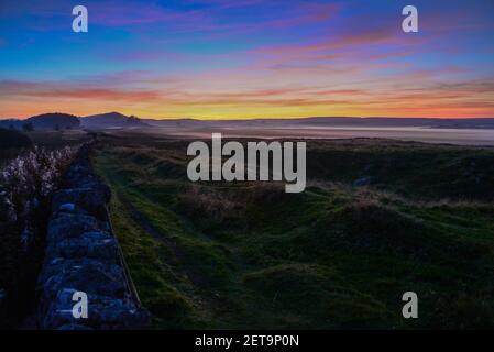 Römische Mauer Land - Blick nach Westen in den Sonnenuntergang aus Nahe Milecastle 33 auf Hadrians Wall Walk in Northumberland Stockfoto