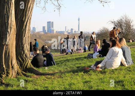 Menschen genießen warme Wintersonne und die Aussicht auf Primrose Hill, im Norden von London, Großbritannien Stockfoto