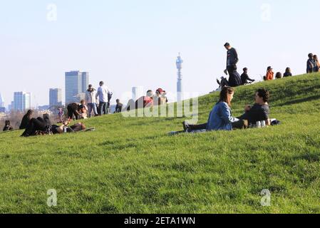 Menschen genießen warme Wintersonne und die Aussicht auf Primrose Hill, im Norden von London, Großbritannien Stockfoto