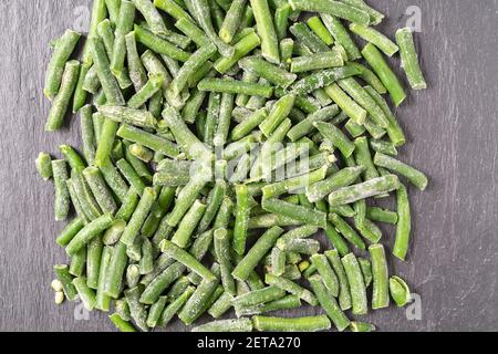 Gefrorene grüne Schnur Bohnen auf schwarzem Hintergrund, flach legen. Stockfoto