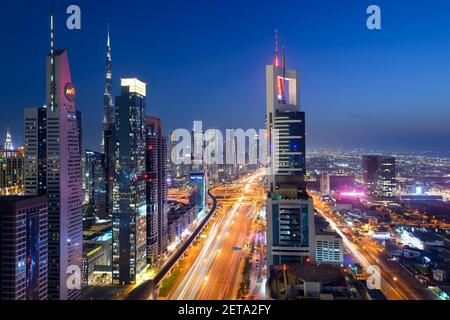 Skyline von Dubai bei Nacht. Mehrere moderne Wolkenkratzer an der Sheikh Zayed Road und der Autobahn in Dubai, Vereinigte Arabische Emirate. Hohe Gebäude im Emirat Dubai. Stockfoto
