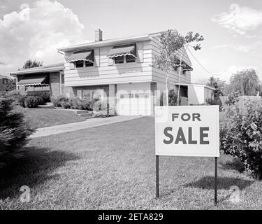 1960S SPLIT-LEVEL-VORSTADTHAUS ZUM VERKAUF SIGN IN FRONT RASEN MIT EINZELGARAGE UND MARKISEN - B22877 HAR001 HARS STRUKTUREN RESIDENZ GEBÄUDE SPLIT-LEVEL SYMBOLISCHE KONZEPTE EBENE SCHWARZ UND WEISS HAR001 ALTMODISCHE DARSTELLUNG Stockfoto