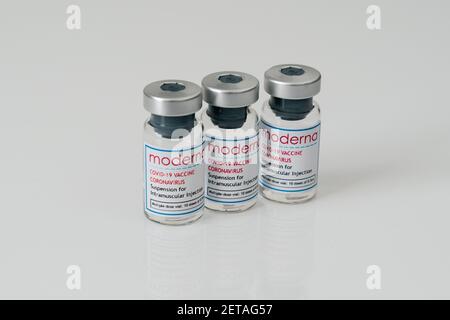 LONDON, ENGLAND - 28. FEBRUAR 2021: Drei Glasfläschchen mit der Moderna COVID Coronavirus COVID-19 Impfstoffdosierungslösung bereit für Stockfoto