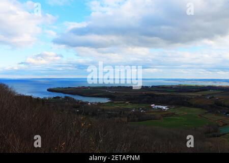 Panoramablick auf Ackerland entlang der Küste von Nova Scotia, mit Blick über das Land zum Meer und zum Horizont. Stockfoto