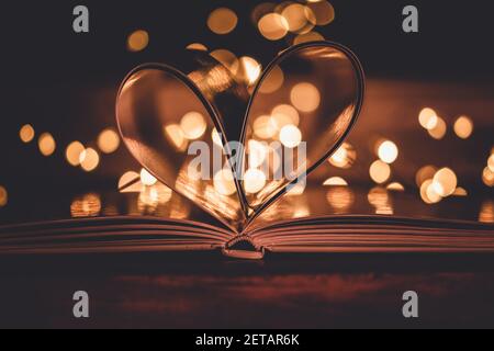 Ein Herz, das mit den Seiten eines Buches geschaffen wurde Ein heller Bokeh Hintergrund Stockfoto