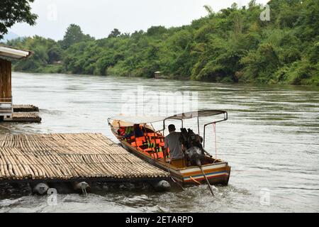 Ein Mann, der ein thailändisches Langschwanz-Boot auf dem Fluss Khwae Noi (Sai Yok) in Kanchanaburi, Thailand, betreibt Stockfoto