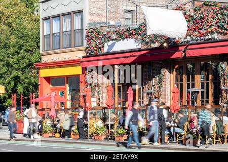 Belebte Straßenszene mit Menschenmassen in Restaurants mit Tische im Freien an der 7th Avenue im West Village Von New York City NYC Stockfoto