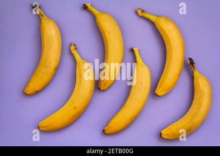 Draufsicht auf Bananas auf violettem Hintergrund Stockfoto