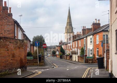 Ein Blick auf die St John's Road in Reading, Großbritannien, gesäumt von Terrassenhäusern mit einem Kirchturm in der Stance. Stockfoto