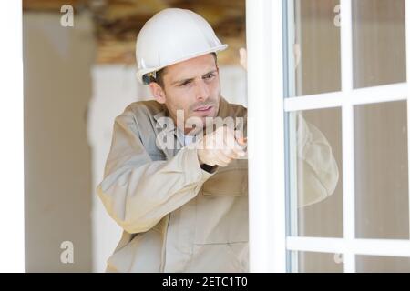 Mann mit einem Schraubendreher auf die Scheibe Stockfoto