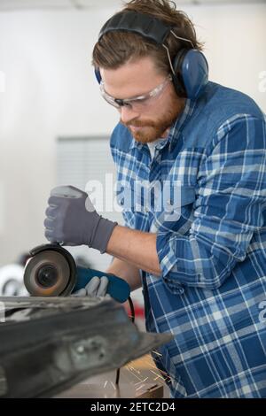 Konzentrierte Arbeiter mit einem Mahlwerk Stockfoto