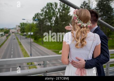 Ein flacher Fokus eines frisch verheirateten Paares auf dem steht Eine Brücke und Blick auf die Umgebung Stockfoto