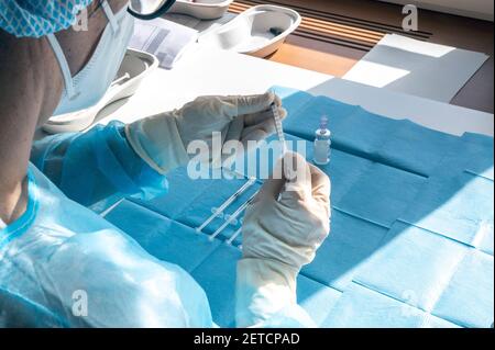 Medizinisches Personal bereitet während eines massiven Impftages in einem Gesundheitszentrum eine Injektion des Impfstoffs vor. Spritzen in Vorbereitung und gebrauchsfertig. Stockfoto