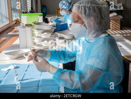 Medizinisches Personal bereitet während eines massiven Impftages in einem Gesundheitszentrum eine Injektion des Impfstoffs vor. Spritzen in Vorbereitung und gebrauchsfertig. Stockfoto