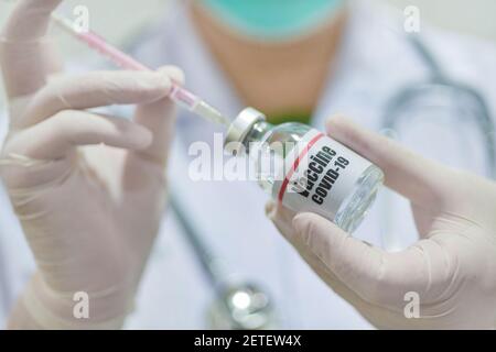 Arzt mit Spritze und Covid-19-Impfstofffläschchen-Medizin, pharmazeutische Forschung und Gesundheitskonzept. Stockfoto