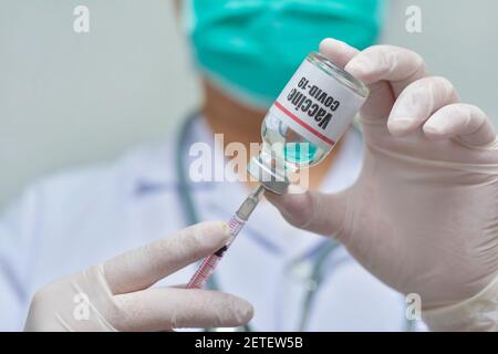 Arzt mit Spritze und Covid-19-Impfstofffläschchen-Medizin, pharmazeutische Forschung und Gesundheitskonzept. Stockfoto