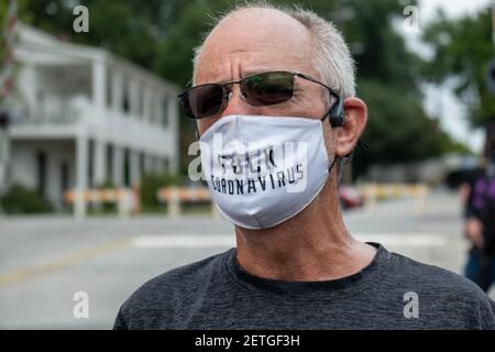 Stone Mountain, GA, USA. August 2020, 15th. Ein Mann, der eine Maske trägt und eine Botschaft über Coronavirus-Proteste während einer Kundgebung zum „Verteidigen des Steinbergs“ trägt. Mehrere rechte Milizgruppen und Gegenprotestierer sollten am Samstag in Stone Mountain, GA, zusammenkommen. Stockfoto