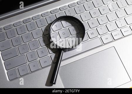 Lupe auf Laptop-Computer-Tastatur. Konzept der Suche und Web-Technologie. Stockfoto
